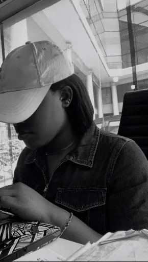 Busayo, founder of Ora, at work in a denim jacket and cap